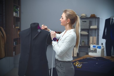 Image of Fashion designer working with mannequin in studio. Creating stylish clothes