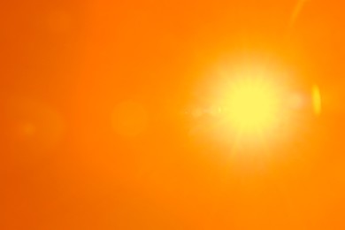 Image of Bright sun in orange sky during hot summer weather
