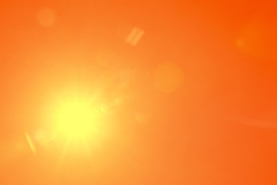 Image of Bright sun in orange sky during hot summer weather