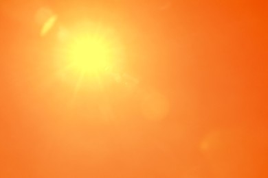 Image of Bright sun in orange sky during hot summer weather