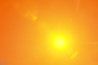 Image of Bright sun in orange sky during hot summer weather