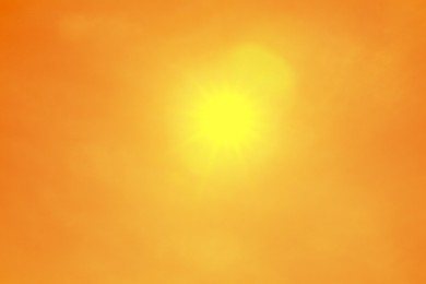 Image of Bright sun in orange sky during hot summer weather