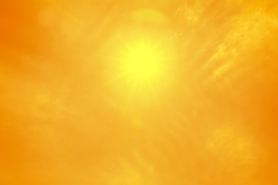 Image of Bright sun in orange sky during hot summer weather