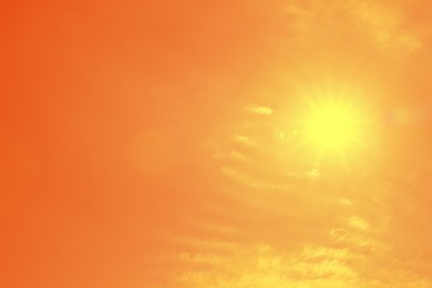 Image of Bright sun in orange sky during hot summer weather