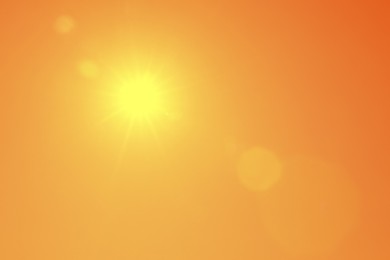 Image of Bright sun in orange sky during hot summer weather
