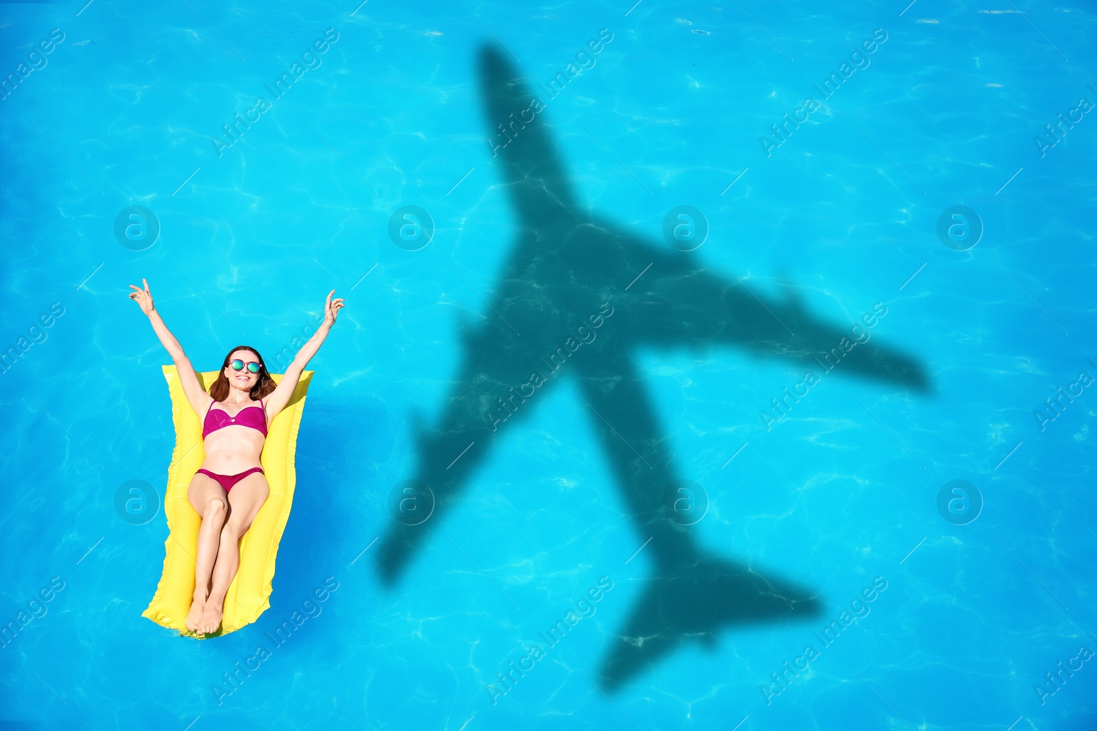 Image of Young woman on inflatable mattress in swimming pool, above view. Flying airplane casting shadow on water