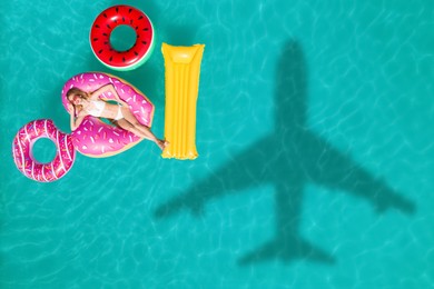 Image of Happy woman with inflatable mattress and rings in swimming pool, top view. Flying airplane casting shadow on water