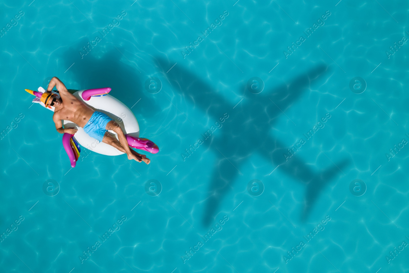 Happy man with inflatable ring in swimming pool, top view. Flying airplane casting shadow on water Image of Happy man with inflatable ring in swimming pool, top view. Flying airplane casting shadow on water