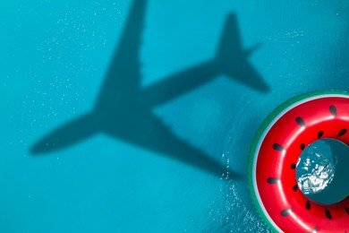 Image of Inflatable ring floating in swimming pool, top view. Flying airplane casting shadow on water