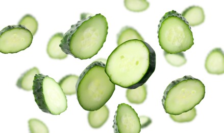 Image of Pieces of fresh cucumbers falling on white background