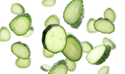 Image of Pieces of fresh cucumbers falling on white background