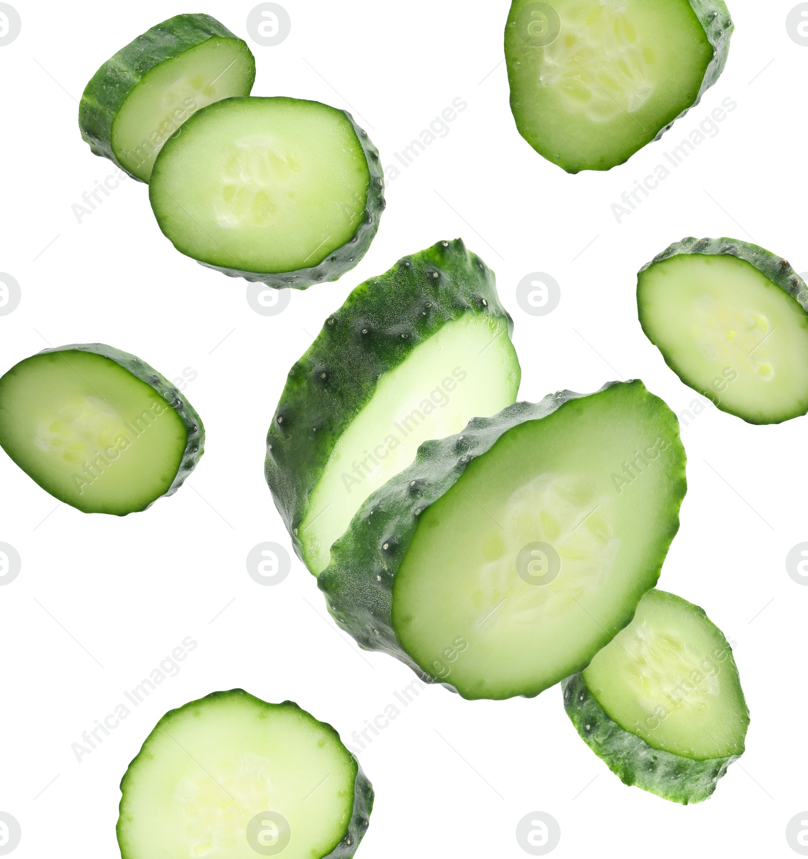 Pieces of fresh cucumbers falling on white background Image of Pieces of fresh cucumbers falling on white background