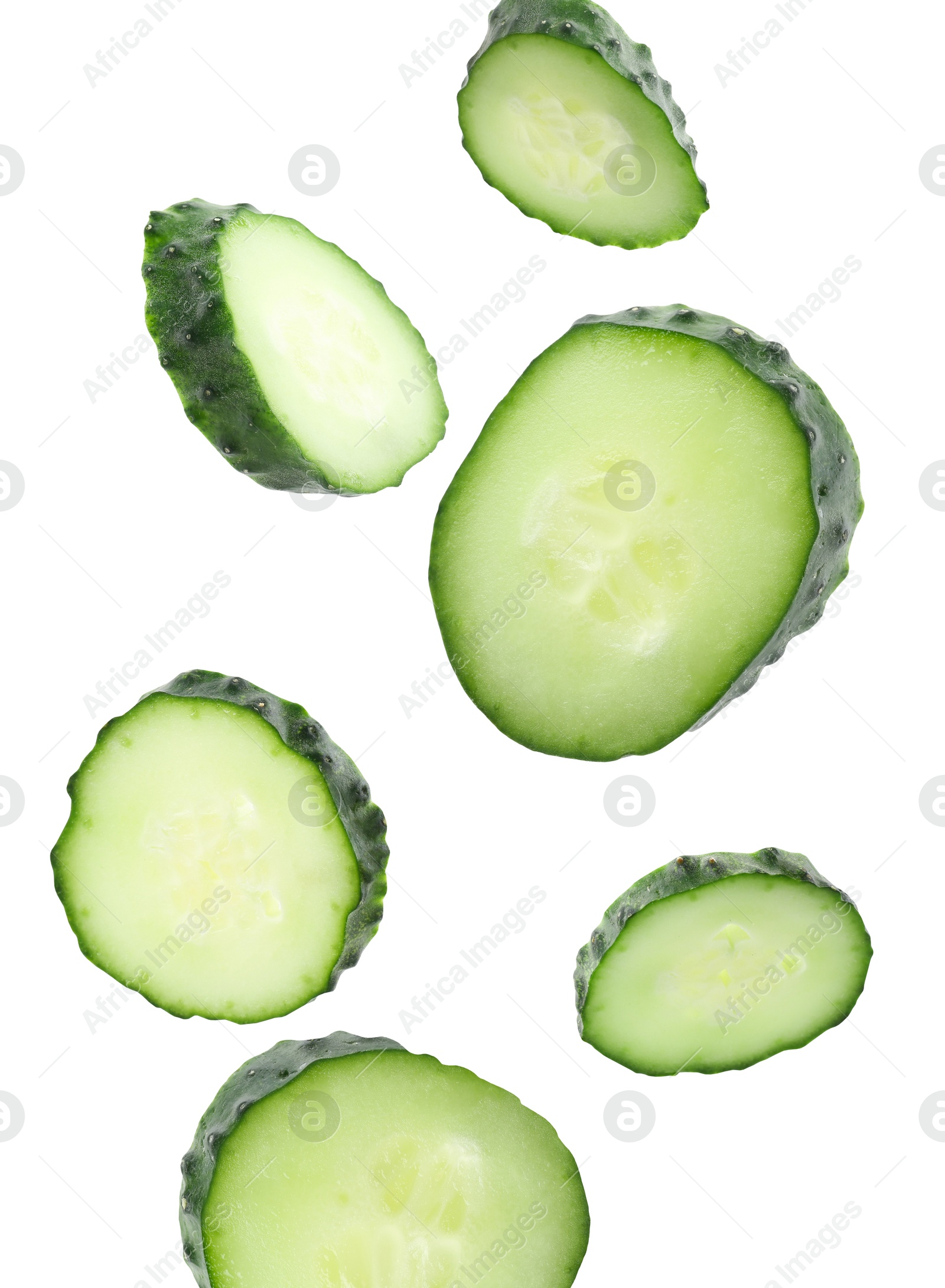 Pieces of fresh cucumbers falling on white background Image of Pieces of fresh cucumbers falling on white background
