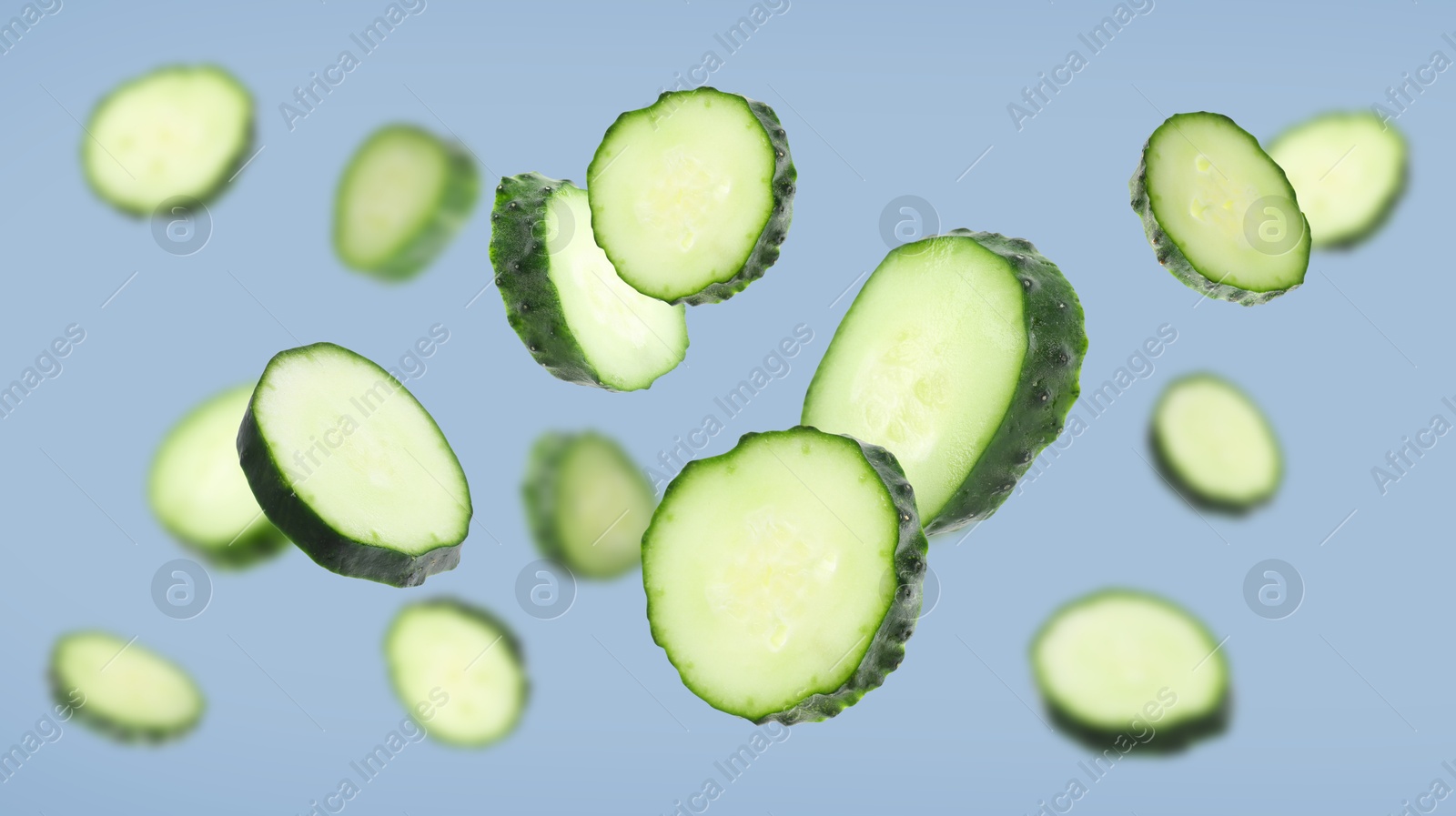 Pieces of fresh cucumbers falling on greyish blue background Image of Pieces of fresh cucumbers falling on greyish blue background