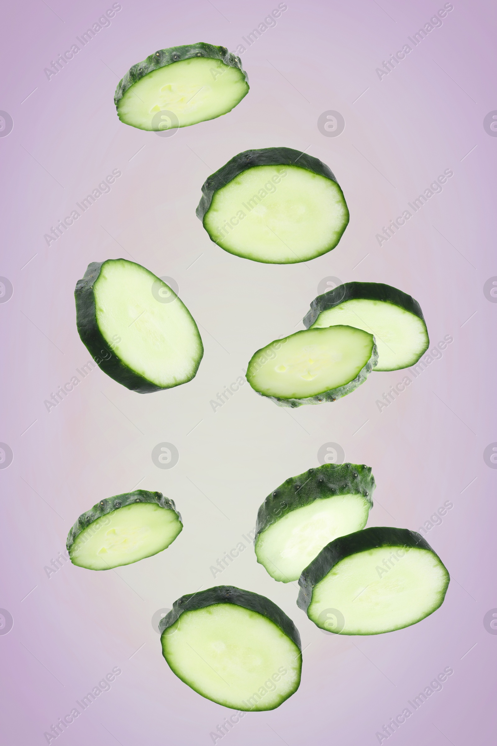 Pieces of fresh cucumbers falling on color gradient background Image of Pieces of fresh cucumbers falling on color gradient background