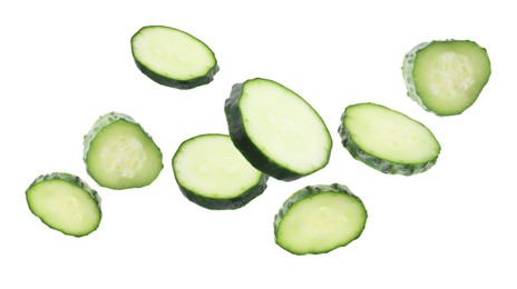 Image of Pieces of fresh cucumbers falling on white background