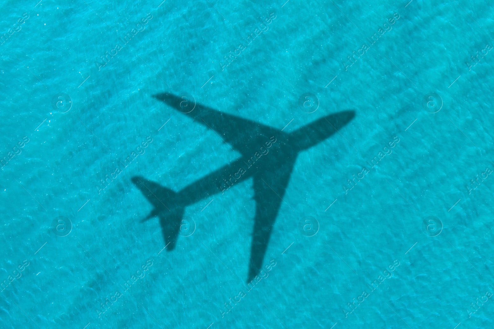 Flying airplane casting shadow on water, top view Image of Flying airplane casting shadow on water, top view