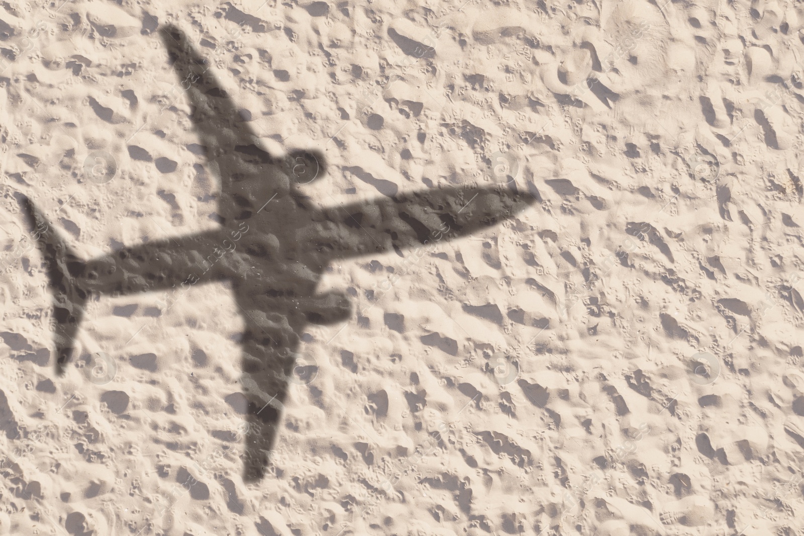 Flying airplane casting shadow on sand, top view Image of Flying airplane casting shadow on sand, top view