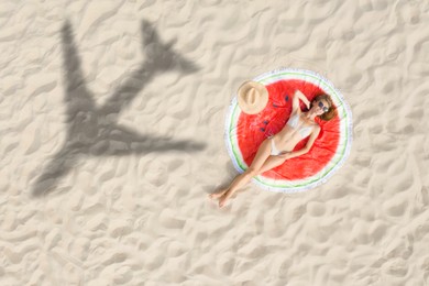 Image of Woman sunbathing on beach, top view. Flying airplane casting shadow on sand