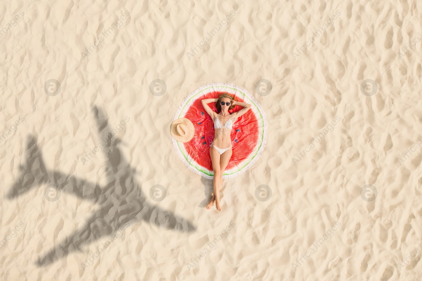 Woman sunbathing on beach, top view. Flying airplane casting shadow on sand Image of Woman sunbathing on beach, top view. Flying airplane casting shadow on sand