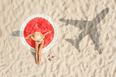 Image of Woman sunbathing on beach, top view. Flying airplane casting shadow on sand