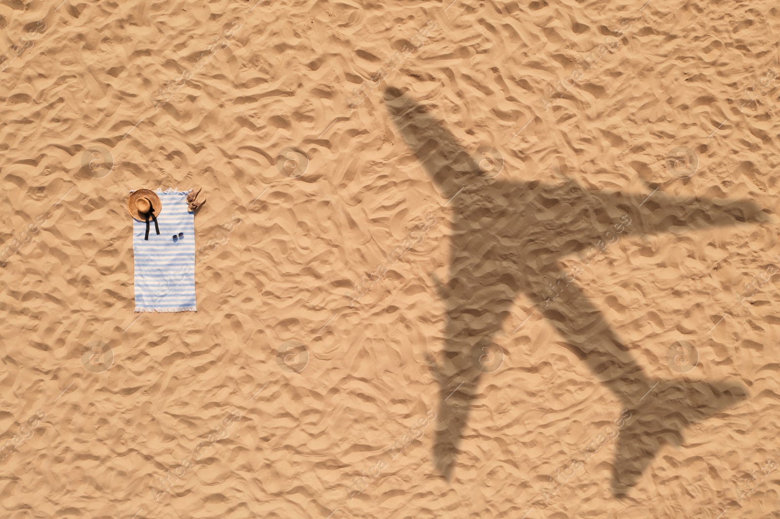 Vacationer's stuff on beach, top view. Flying airplane casting shadow on sand Image of Vacationer's stuff on beach, top view. Flying airplane casting shadow on sand
