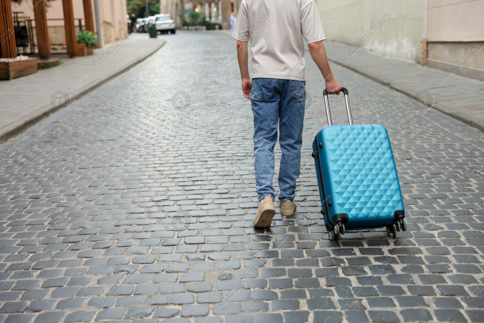 Goodbye. Man with luggage walking on city street, closeup. Space for text Photo of Goodbye. Man with luggage walking on city street, closeup. Space for text
