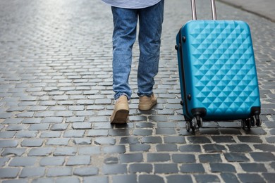 Photo of Goodbye. Man with luggage walking on city street, closeup. Space for text
