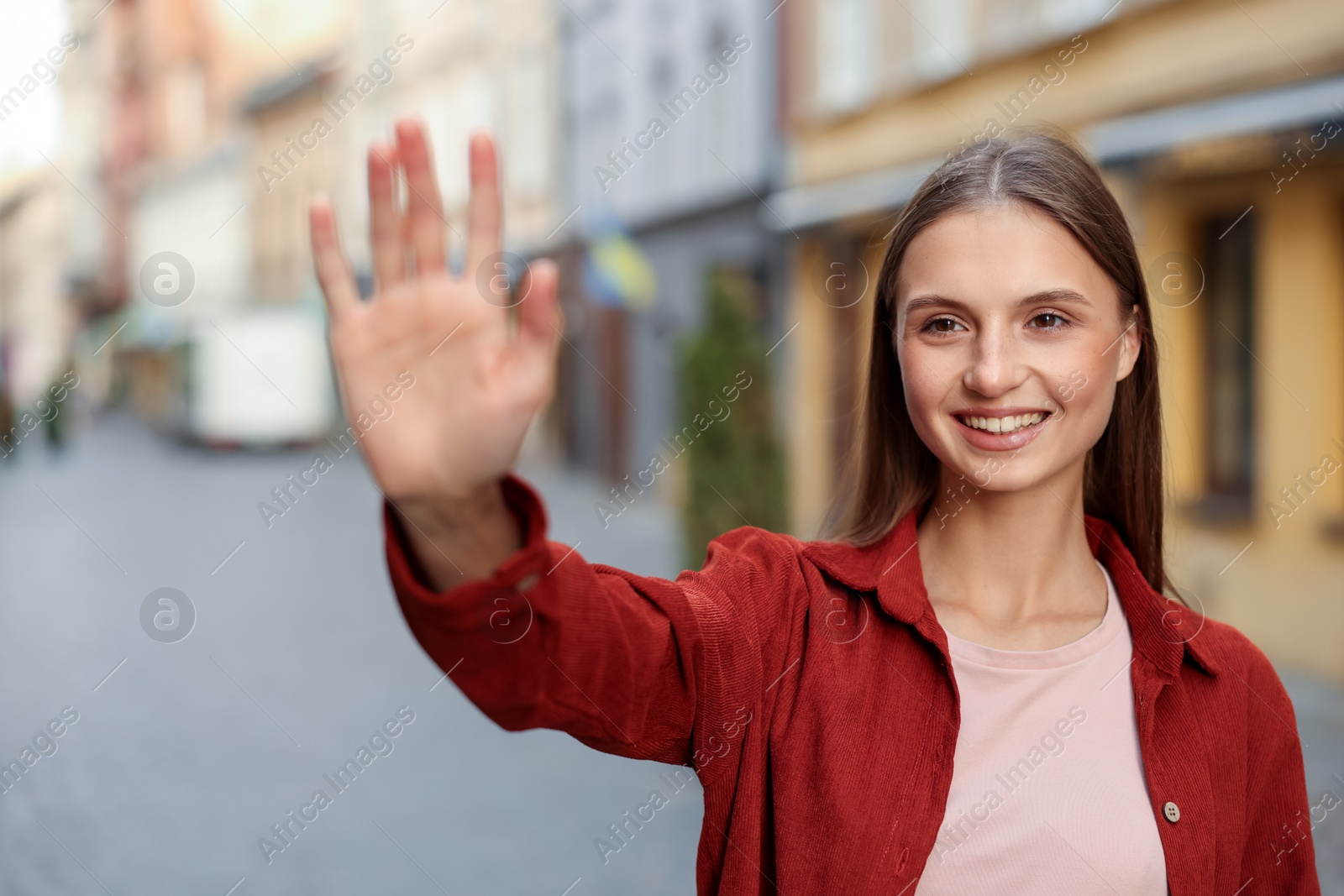 Goodbye. Happy woman waving on city street Photo of Goodbye. Happy woman waving on city street