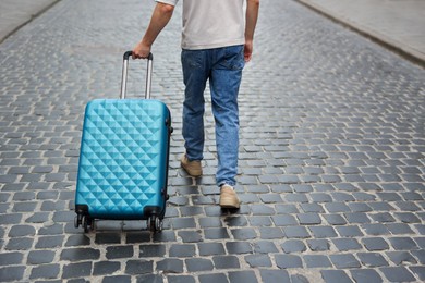 Photo of Goodbye. Man with luggage walking on city street, closeup. Space for text