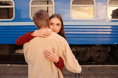 Photo of Goodbye. Lovely couple hugging on platform of railway station