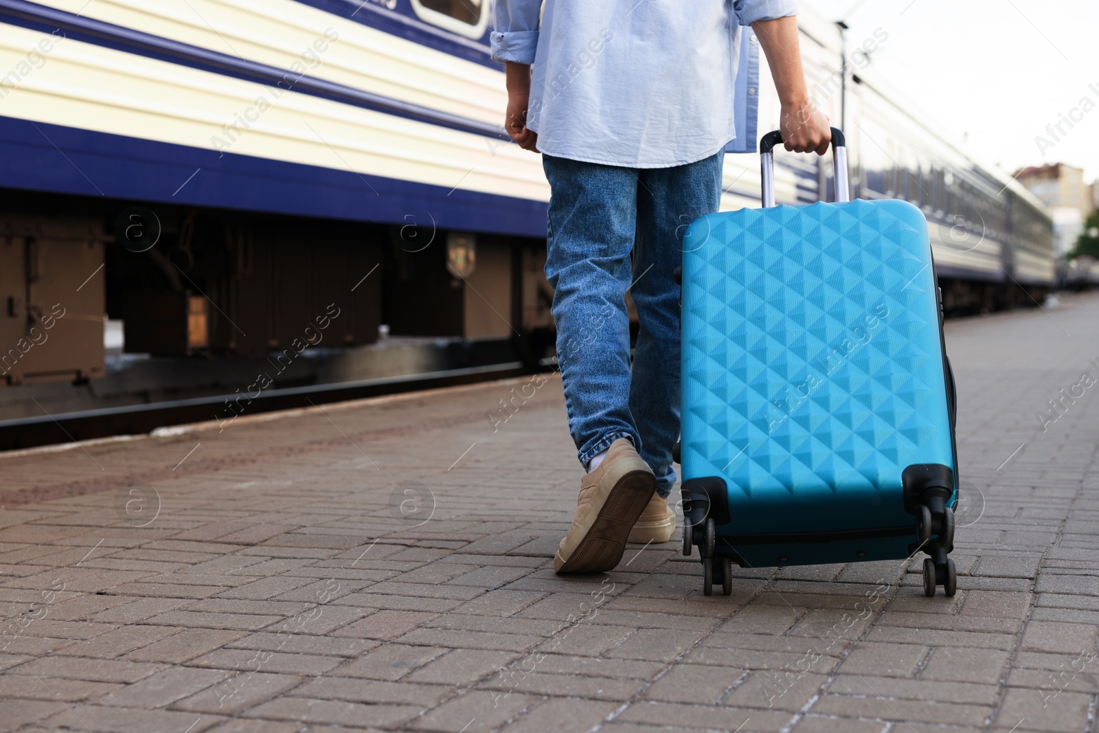 Photo of Goodbye. Man with luggage on platform of railway station, closeup