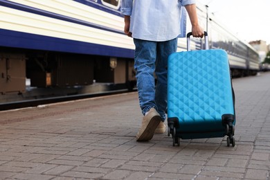 Photo of Goodbye. Man with luggage on platform of railway station, closeup