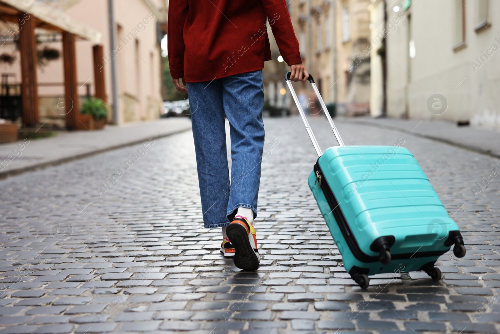 Photo of Goodbye. Woman with luggage walking on city street, closeup