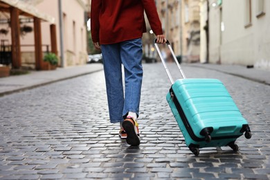 Photo of Goodbye. Woman with luggage walking on city street, closeup