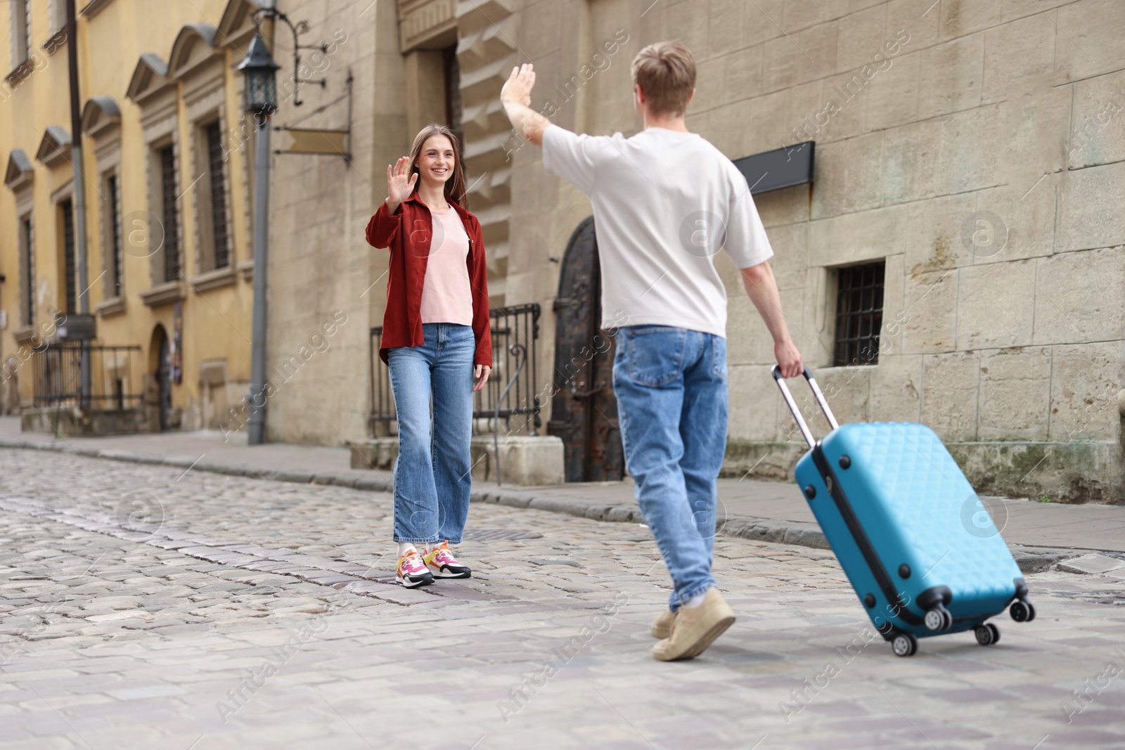 Goodbye. Man waving to his girlfriend outdoors, space for text Photo of Goodbye. Man waving to his girlfriend outdoors, space for text