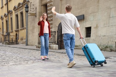 Photo of Goodbye. Man waving to his girlfriend outdoors, space for text