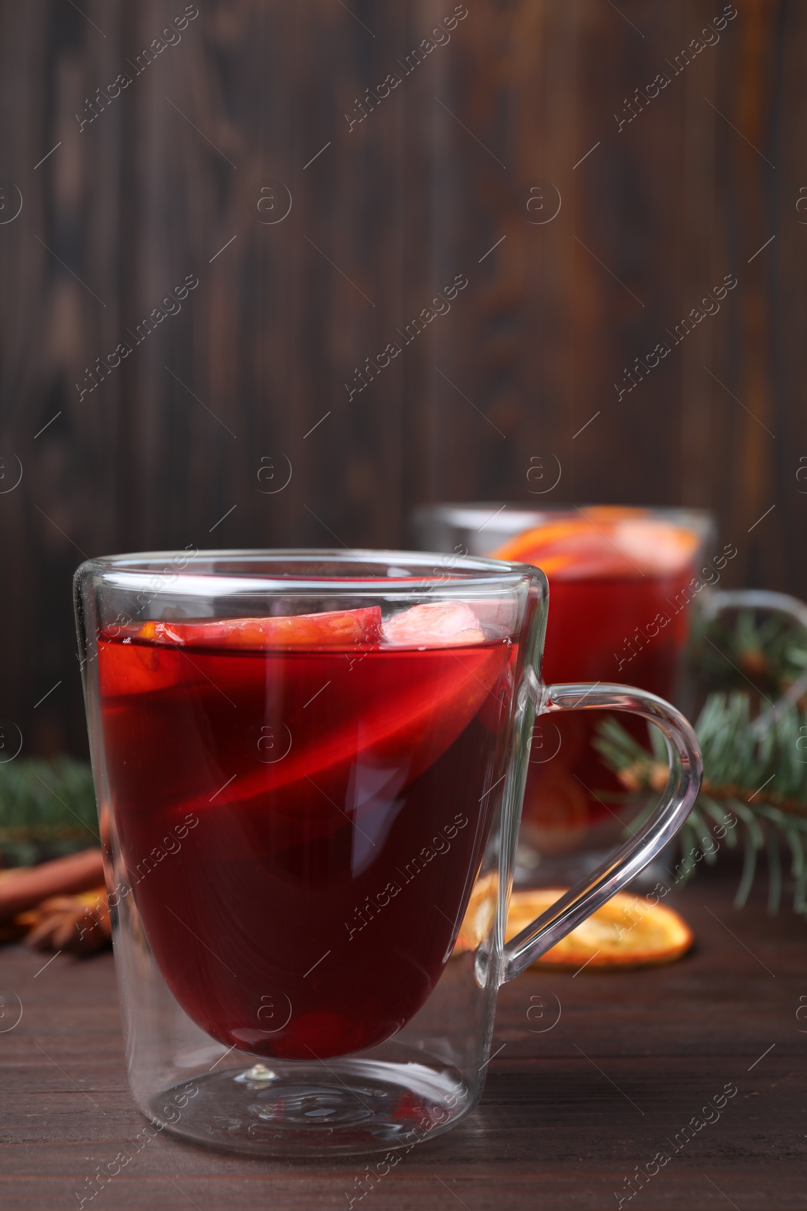 Delicious hot mulled wine on wooden table Photo of Delicious hot mulled wine on wooden table