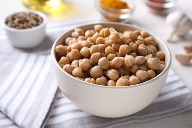 Photo of Bowl with delicious chickpeas on table, closeup
