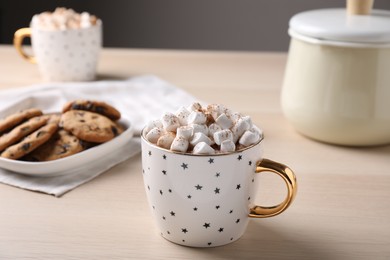 Photo of Cup of hot drink with marshmallows on wooden table,