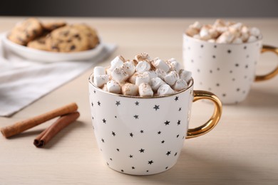 Photo of Cup of hot drink with marshmallows on wooden table,