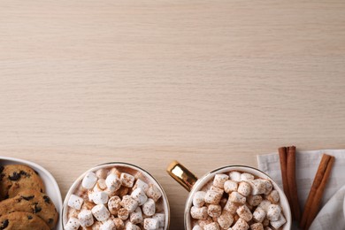 Photo of Hot drink with marshmallows and cookies on wooden table, flat lay. Space for text