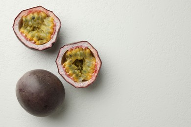 Photo of Fresh passion fruits on white table, flat lay. Space for text