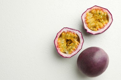 Photo of Fresh passion fruits on white table, flat lay. Space for text