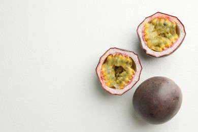 Photo of Fresh passion fruits on white table, flat lay. Space for text