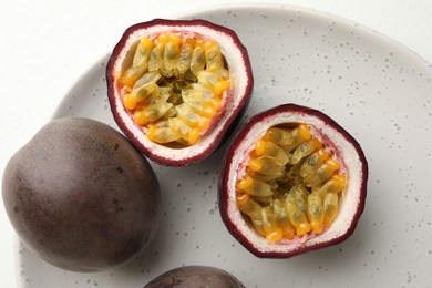 Photo of Fresh passion fruits on white table, closeup
