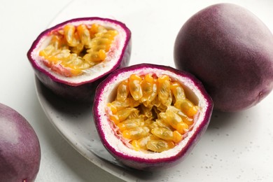 Photo of Fresh passion fruits on white table, closeup