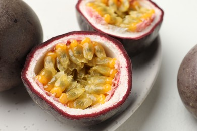Photo of Fresh passion fruits on white table, closeup