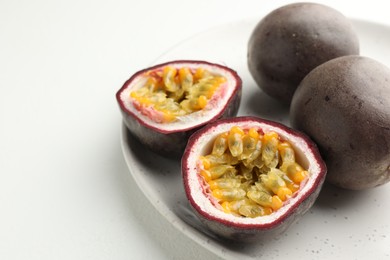 Photo of Fresh passion fruits on white table, closeup. Space for text