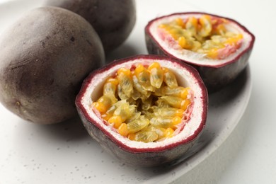 Photo of Fresh passion fruits on white table, closeup